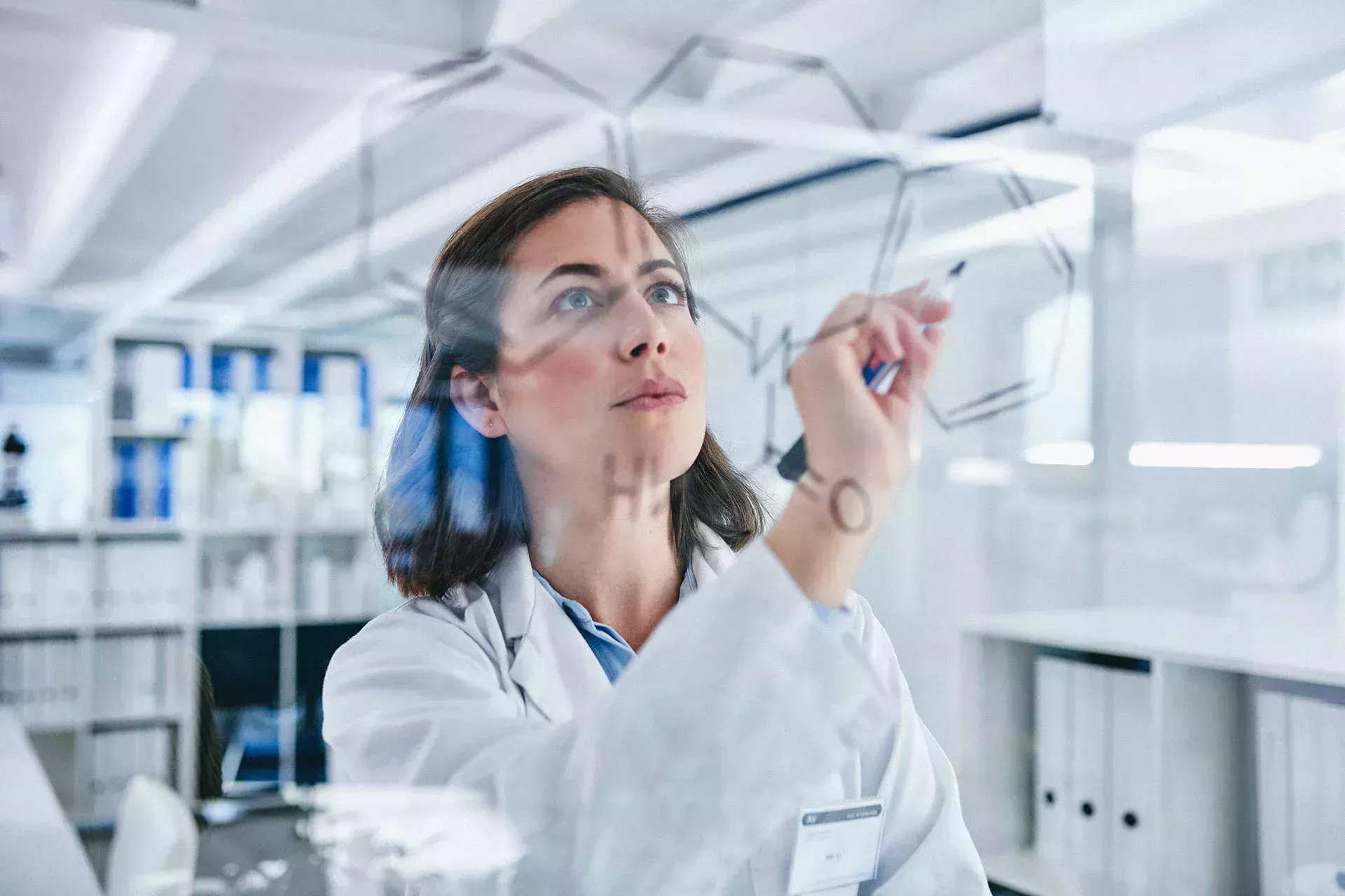 Woman in the lab writing something on a blackboard