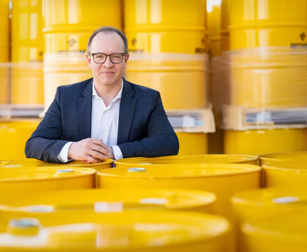 Chistoph Hundertmark stands in front of yellow barrels