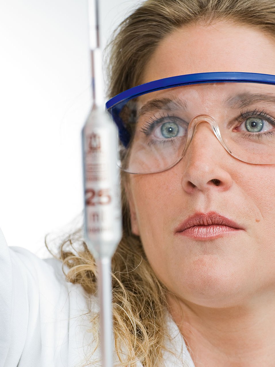 A woman wearing safety goggles performs a test