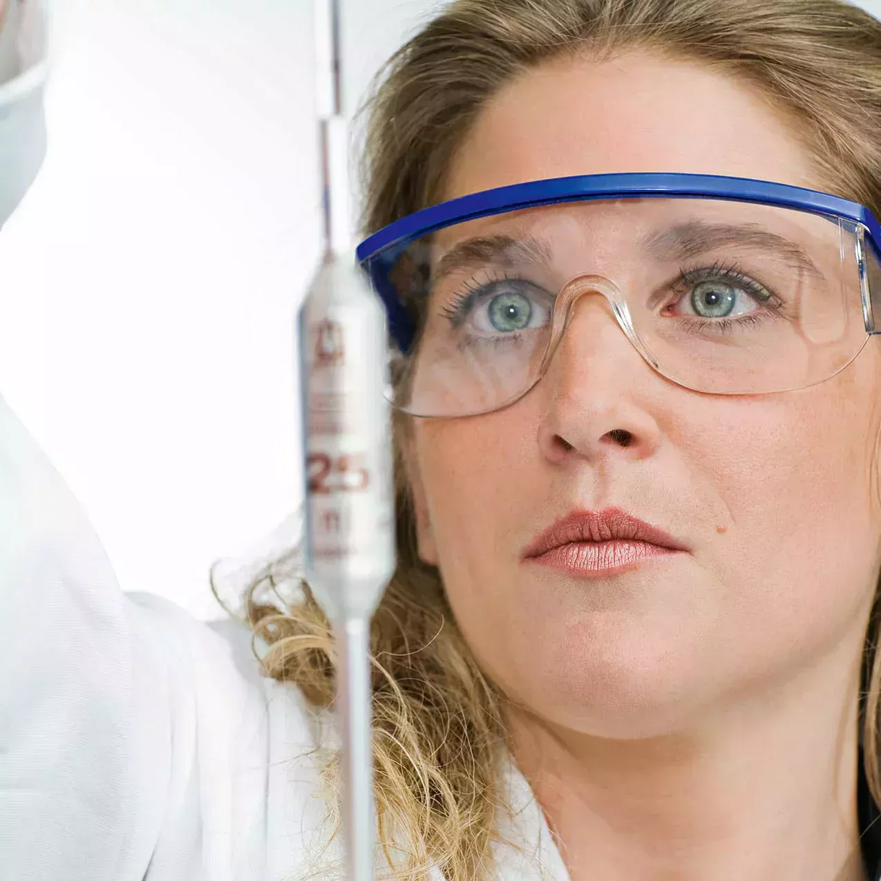 A woman wearing safety goggles performs a test